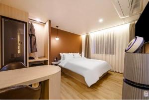 um quarto de hotel com uma cama e uma secretária em Brown Dot Hotel Yeonsan em Busan