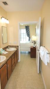 a bathroom with two sinks and a large window at Johns Pass Condo's- Fully Remote in St. Pete Beach