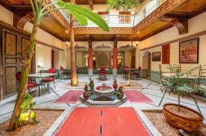 a lobby with a fountain in the middle of a building at Riad Atlas Acacia in Marrakesh