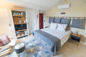 1 dormitorio con 1 cama, 1 sofá y 1 silla en La Terrasse - A Peaceful Place in the Forest, en Concots