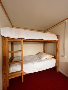 a bunk bed with two bunk beds in a room at Hostal B&B Coastal Natales in Puerto Natales