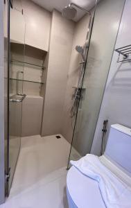 a bathroom with a shower and a toilet at Sky Park Laguna 1bdr Lake View in Thalang