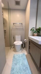 uma casa de banho com um WC, um lavatório e um tapete azul em Sky Park Laguna 1bdr Lake View em Thalang