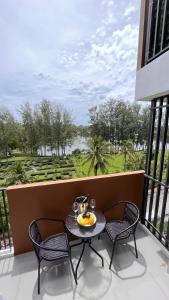 a table with a bowl of fruit on a balcony at Sky Park Laguna 1bdr Lake View in Thalang