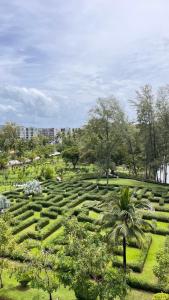un jardín con una palmera en un campo en Sky Park Laguna 1bdr Lake View en Thalang