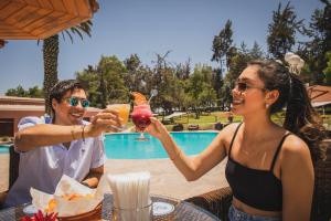 a man and woman sitting at a table with drinks at Wyndham Costa del Sol Arequipa in Arequipa