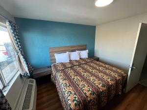 1 dormitorio con 1 cama con pared azul en Super 7 inn, en Joplin
