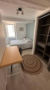 a small bedroom with a bed and a table and a rug at Appartement Cosy à Collobrières in Collobrières +17 photos