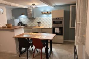 a kitchen with a wooden table and some chairs at Appartement Cosy à Collobrières in Collobrières