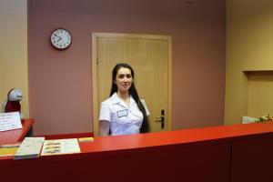 a woman is standing in front of a reception desk at Fire Inn in Kyiv