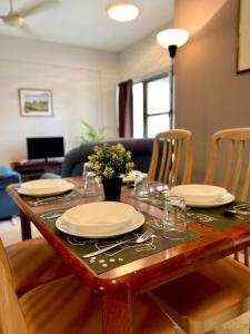 a dining room table with plates and glasses on it at The Hillside Home in Bentong