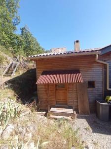 Cette petite cabane en bois dispose d'une véranda et d'une porte. dans l'établissement La Laouze - Small wooden house Eco-Low-tech, à Rogues