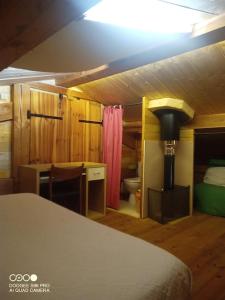 1 dormitorio con cama, escritorio y baño en La Laouze - Small wooden house Eco-Low-tech, en Rogues