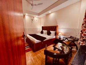 a bedroom with a bed and a table and chairs at River Grand Resort - A Peaceful Stay Kempty Fall Mussoorie in Mussoorie