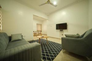 ein Wohnzimmer mit 2 Sofas und einem TV in der Unterkunft Kayla's Court Apartments in Accra