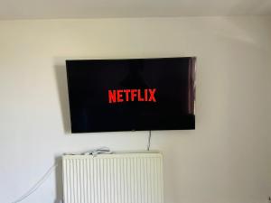 un televisor en una pared con un cartel de netflix en él en Chatham hilltop view en Chatham