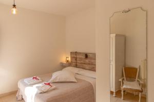 a bedroom with a bed with a mirror and a chair at Torre della Botonta in Castel Ritaldi