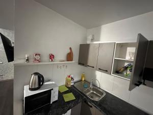 a small kitchen with a sink and a microwave at Comfy apartment in the center in Chişinău