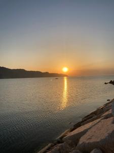 um pôr-do-sol sobre uma grande massa de água em la casa degli Archi em Pesaro