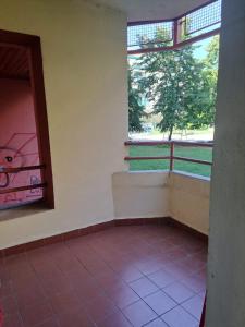an empty room with a window and a tiled floor at Apartman Kosa in Bežanija