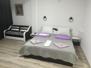 een slaapkamer met een bed met paarse lakens en een stoel bij Vesna Lake Apartments in Veles