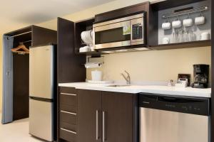 a kitchen with a sink and a refrigerator at Home2 Suites by Hilton Fort St. John in Fort Saint John