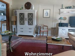 a living room with a white cabinet and a table at Alte Schule Mankmuß in Karstädt