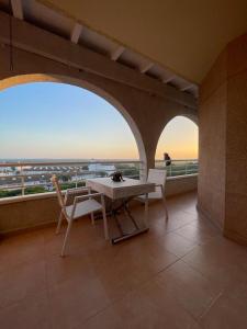 een tafel en stoelen op een balkon met uitzicht bij Apartamento El Portil, Playas del Sur in El Portil