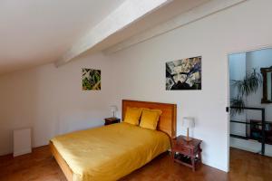a bedroom with a large bed with yellow pillows at Les Airis in Avignon