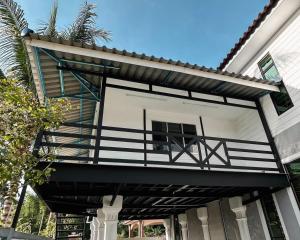 a house with a balcony on the side of it at D'Village Homestay Kota Bharu in Kota Bharu