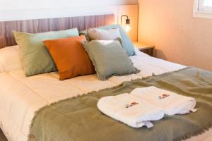 een bed met kussens en handdoeken erop bij Quinta La Pintada in San Juan