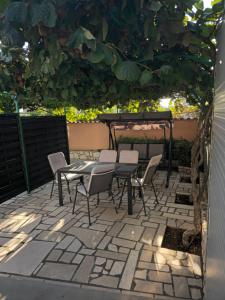 a patio with a table and chairs under a tree at Apartments Vuceric in Peroj