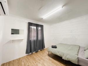 a white room with a bed and a window at D'Village Homestay Kota Bharu in Kota Bharu