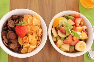 two bowls of cereal and fruit and snacks on a table at Niriides Luxury Villas in Methoni