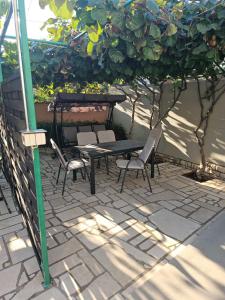 patio con tavolo e sedie sotto ombrellone di Apartments Vuceric a Peroj