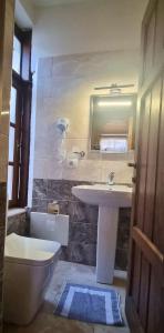 a bathroom with a sink and a toilet and a mirror at Hotel Gorica - UNESCO quarter in Berat