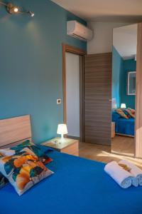 ein blaues Schlafzimmer mit einem Bett und einem Spiegel in der Unterkunft Acacia House - Few meters from the beach in Villaggio San Leonardo