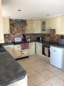 a large kitchen with white cabinets and appliances at The Stables Kenilworth in Kenilworth