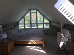 a bedroom with a bed and two windows at The Stables Kenilworth in Kenilworth