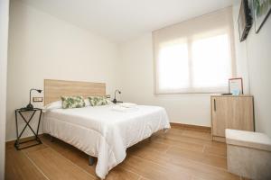 a white bedroom with a bed and a window at El Maestrazgo in Xert