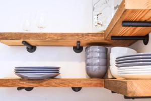 a wooden shelf with plates and dishes on it at Sleeps 10! Minutes to Parris Island & Downtown in Beaufort