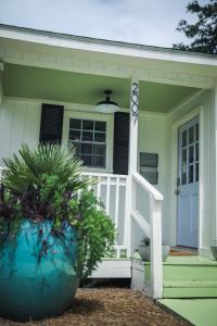 a green house with a white porch and a door at Sleeps 10! Minutes to Parris Island & Downtown in Beaufort