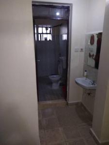 a bathroom with a toilet and a sink at Ole kerai #101 in Nairobi