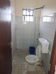 a bathroom with a toilet and a window at Ole kerai #101 in Nairobi