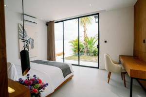 um quarto com uma cama, uma secretária e uma janela em Garden Villa Pererenan by BREIG em Canggu