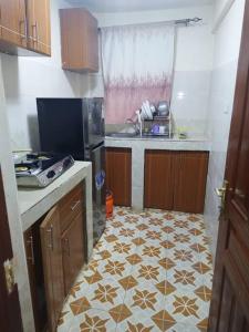 a kitchen with a tiled floor and a sink at Ole kerai #101 in Nairobi