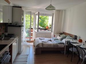 a bedroom with a bed and a table and a window at Cozy Apartment in Budapest