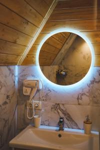 uma casa de banho com um lavatório e um espelho em Misty Rocks Kazbegi em Stepantsminda