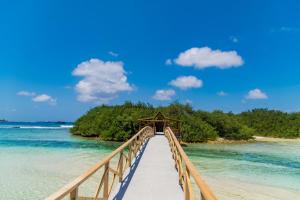 a bridge over the water on a beach at Aasna Inn in Thulusdhoo