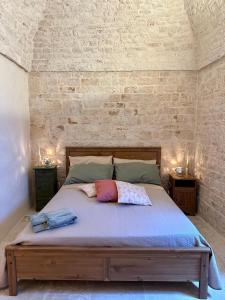 a bed with two pillows on it in a room at La Casetta in Alberobello